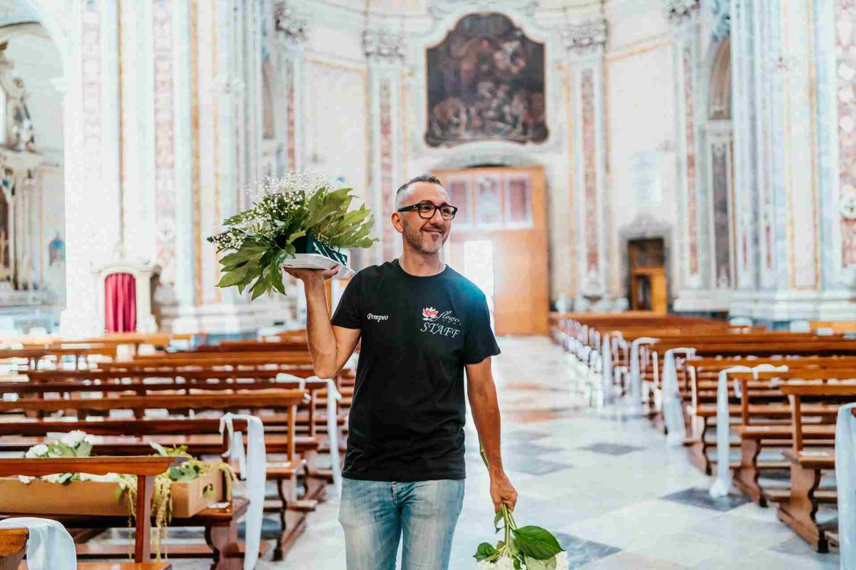Un membro della famiglia sistema i fiori su un altare
