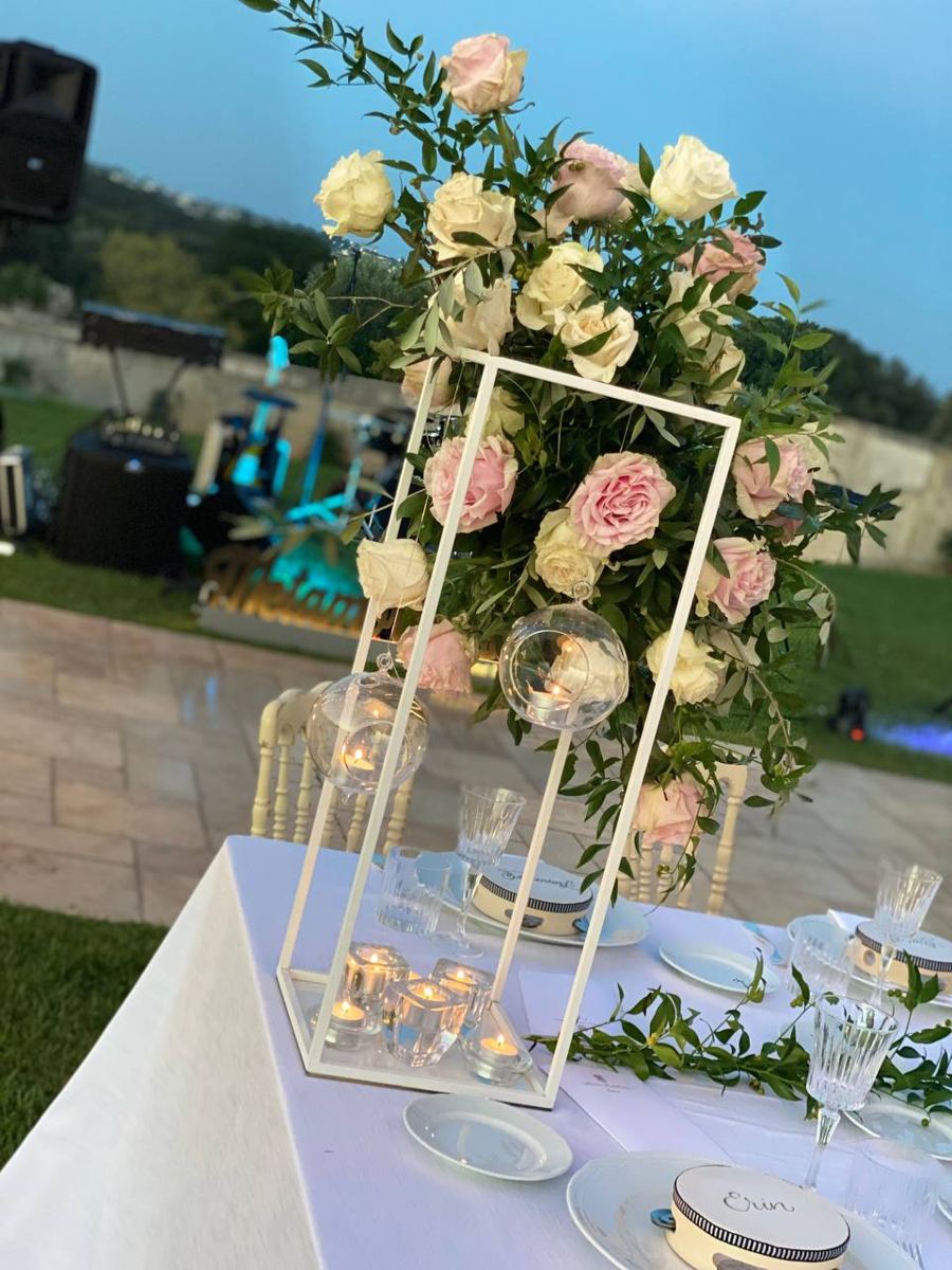Struttura geometrica bianca con rose rosa