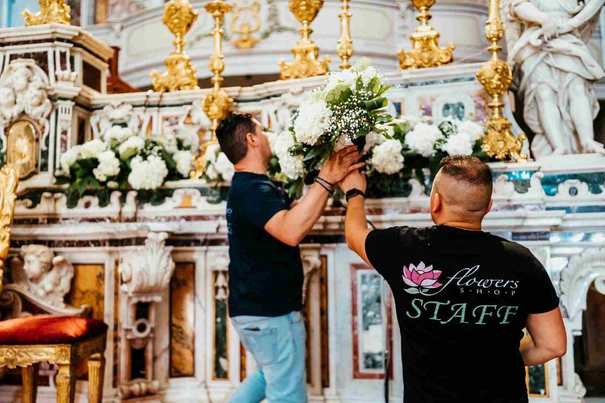 Altare barocco dorato con composizioni di fiori bianchi