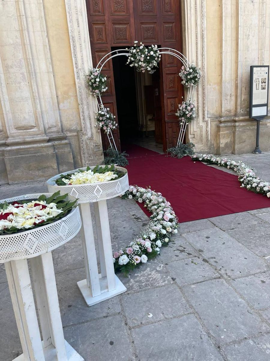 Portale di una chiesa con tappeto rosso e composizioni ai lati